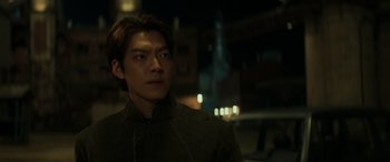 A young man is standing in the dark outside