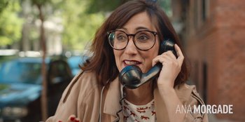 Movie still from “All About Gila” (2022), directed by Arturo González-Campos – A woman with glasses is talking on a phone; Close Up shot, Over the shoulder angle