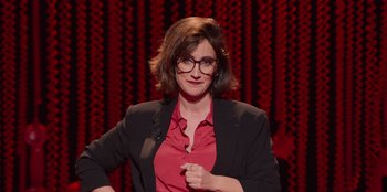 Movie still from “All About Gila” (2022), directed by Arturo González-Campos – A woman in a red shirt and black jacket; Close Up shot, Over the shoulder angle