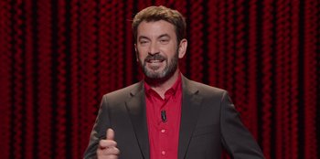 Movie still from “All About Gila” (2022), directed by Arturo González-Campos – A man in a red shirt and black jacket; Medium shot, High angle