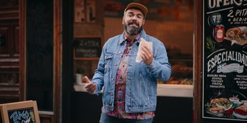 Movie still from “All About Gila” (2022), directed by Arturo González-Campos – A man in a denim jacket holding a piece of paper; Medium shot, Low angle