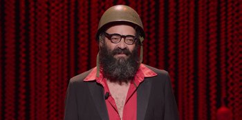 Movie still from “All About Gila” (2022), directed by Arturo González-Campos – A man with a beard wearing a helmet; Medium shot, Low angle