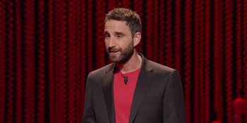 Movie still from “All About Gila” (2022), directed by Arturo González-Campos – A man in a suit and a red shirt; Close Up shot, Over the shoulder angle