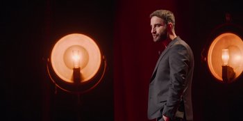 Movie still from “All About Gila” (2022), directed by Arturo González-Campos – A man standing next to an electric lamp; Medium shot, Low angle
