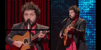 Movie still from “All About Gila” (2022), directed by Arturo González-Campos – A man with a beard playing a guitar; Medium shot, High angle