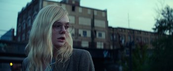 Movie still from “All the Bright Places” (2020), directed by Brett Haley – A woman wearing glasses and a jacket looking to her left; Close Up shot, Low angle