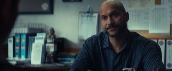 Movie still from “All the Bright Places” (2020), directed by Brett Haley – A man with a bald head sitting at a table; Close Up shot, Over the shoulder angle
