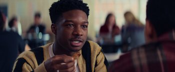 Movie still from “All the Bright Places” (2020), directed by Brett Haley – A man eating a piece of food while sitting at a table; Close Up shot, Over the shoulder angle