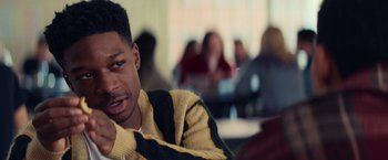 Movie still from “All the Bright Places” (2020), directed by Brett Haley – A man sitting in front of a group of people in a room; Close Up shot, Over the shoulder angle