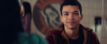 Movie still from “All the Bright Places” (2020), directed by Brett Haley – A young man is smiling for the camera; Close Up shot, Over the shoulder angle