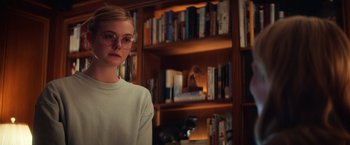 Movie still from “All the Bright Places” (2020), directed by Brett Haley – A girl with glasses standing in front of a book shelf; Medium shot, Over the shoulder angle