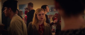 Movie still from “All the Bright Places” (2020), directed by Brett Haley – A group of people standing in a room with drinks; Medium shot, Over the shoulder angle