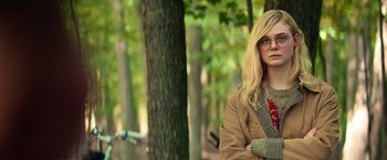 Movie still from “All the Bright Places” (2020), directed by Brett Haley – A woman with blonde hair wearing glasses and a plaid jacket; Medium shot, Over the shoulder angle