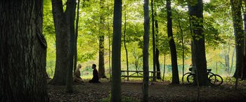 Movie still from “All the Bright Places” (2020), directed by Brett Haley – Two people sitting in the middle of a forest; Extreme Wide shot, High angle