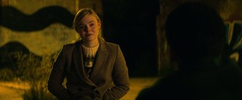 Movie still from “All the Bright Places” (2020), directed by Brett Haley – A woman in a suit and sweater standing in front of a wall; Medium shot, Over the shoulder angle