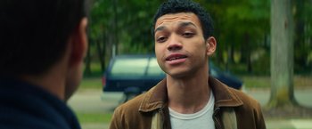 Movie still from “All the Bright Places” (2020), directed by Brett Haley – A man with a beard and a jacket on looking at the camera; Close Up shot, Over the shoulder angle