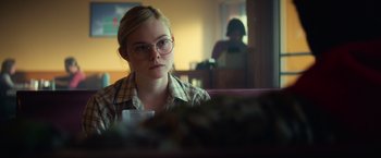 Movie still from “All the Bright Places” (2020), directed by Brett Haley – A woman sitting in front of a plate of food in a room; Close Up shot, Over the shoulder angle