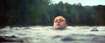 Movie still from “All the Bright Places” (2020), directed by Brett Haley – A woman is swimming in a body of water; Close Up shot, Low angle
