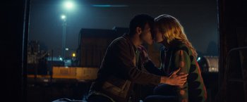 Movie still from “All the Bright Places” (2020), directed by Brett Haley – A man and a woman kissing in the dark at night; Medium shot, Low angle