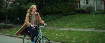 Movie still from “All the Bright Places” (2020), directed by Brett Haley – A woman is riding a bike down the street; Wide shot, Low angle