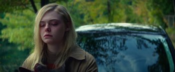 Movie still from “All the Bright Places” (2020), directed by Brett Haley – A young blonde haired woman in a brown jacket; Close Up shot, High angle