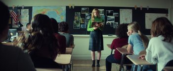 Movie still from “All the Bright Places” (2020), directed by Brett Haley – A woman standing in front of a group of people in a classroom; Medium shot, Over the shoulder angle