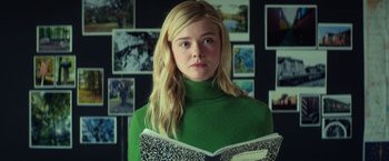 Movie still from “All the Bright Places” (2020), directed by Brett Haley – A woman in a green sweater holding a book; Medium shot, Low angle
