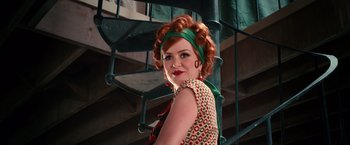 Movie still from “The Great Gatsby” (2013), directed by Baz Luhrmann – A woman with red curly hair wearing a green head scarf; Medium shot, Low angle