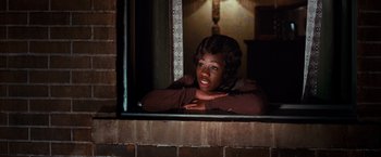 Movie still from “The Great Gatsby” (2013), directed by Baz Luhrmann – A woman leaning on a window sill looking out of the window; Medium shot, Over the shoulder angle