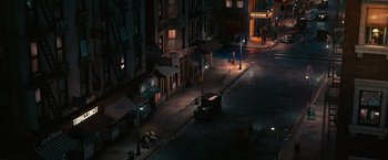 Movie still from “The Great Gatsby” (2013), directed by Baz Luhrmann – A street scene at night with a car parked on the side of the road; Extreme Wide shot, High angle
