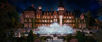 Movie still from “The Great Gatsby” (2013), directed by Baz Luhrmann – A fountain in front of a large building at night time; Extreme Wide shot, High angle