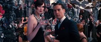 Movie still from “The Great Gatsby” (2013), directed by Baz Luhrmann – A man and a woman holding drinks at an event; Medium shot, Low angle