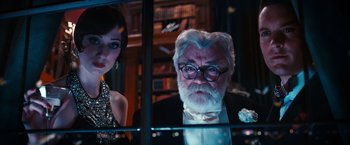 Movie still from “The Great Gatsby” (2013), directed by Baz Luhrmann – An older man and a woman in a room; Medium shot, Over the shoulder angle