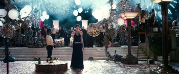 Movie still from “The Great Gatsby” (2013), directed by Baz Luhrmann – A woman in a black dress standing on a stage; Wide shot, Over the shoulder angle