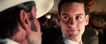 Movie still from “The Great Gatsby” (2013), directed by Baz Luhrmann – A person wearing a suit and tie; Close Up shot, Over the shoulder angle