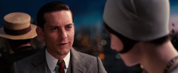 Movie still from “The Great Gatsby” (2013), directed by Baz Luhrmann – A man in a suit and a hat talking to a woman in a hat; Close Up shot, Over the shoulder angle