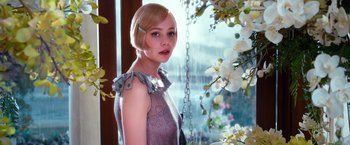 Movie still from “The Great Gatsby” (2013), directed by Baz Luhrmann – A woman in a dress standing in front of a window; Close Up shot, Over the shoulder angle