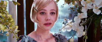 Movie still from “The Great Gatsby” (2013), directed by Baz Luhrmann – A person with short blonde hair; Close Up shot, Over the shoulder angle