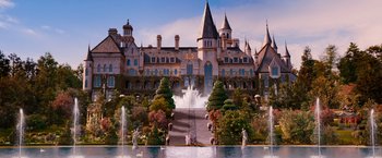 Movie still from “The Great Gatsby” (2013), directed by Baz Luhrmann – A fountain in front of a large castle like building; Extreme Wide shot, High angle