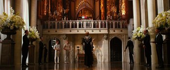 Movie still from “The Great Gatsby” (2013), directed by Baz Luhrmann – A woman in a black dress standing in front of two men; Extreme Wide shot, Low angle