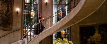 Movie still from “The Great Gatsby” (2013), directed by Baz Luhrmann – A woman is walking down the stairs of a hotel; Wide shot, Low angle