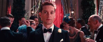 Movie still from “The Great Gatsby” (2013), directed by Baz Luhrmann – A man in a suit and a bow tie in front of a crowd; Close Up shot, Low angle