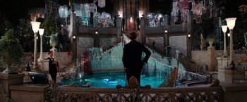 Movie still from “The Great Gatsby” (2013), directed by Baz Luhrmann – A man standing in front of an indoor fountain; Extreme Wide shot, High angle