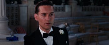 Movie still from “The Great Gatsby” (2013), directed by Baz Luhrmann – A person wearing a suit and a bow tie; Close Up shot, Over the shoulder angle