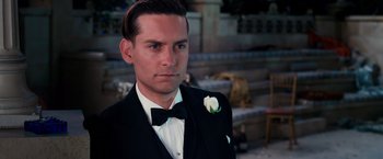 Movie still from “The Great Gatsby” (2013), directed by Baz Luhrmann – A person wearing a suit and a bow tie; Close Up shot, Over the shoulder angle