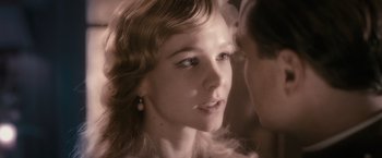 Movie still from “The Great Gatsby” (2013), directed by Baz Luhrmann – A young woman with a feather boa in her hair; Close Up shot, Over the shoulder angle