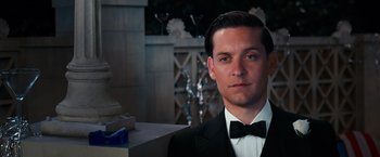 Movie still from “The Great Gatsby” (2013), directed by Baz Luhrmann – A man in a suit and bow tie; Close Up shot, Over the shoulder angle