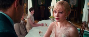 Movie still from “The Great Gatsby” (2013), directed by Baz Luhrmann – Two people sitting at a table in front of each other; Close Up shot, Over the shoulder angle