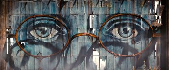 Movie still from “The Great Gatsby” (2013), directed by Baz Luhrmann – An eye glasses mural painted on the side of a building; Extreme Close Up shot, Low angle