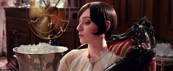 Movie still from “The Great Gatsby” (2013), directed by Baz Luhrmann – A woman sitting in a chair wearing a white shirt; Close Up shot, Over the shoulder angle